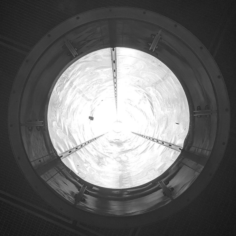 the end of a reflective metal tube, with light shining from the inside