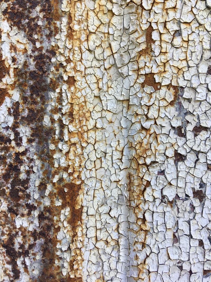 rusty metal beneath chipped white paint